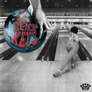 Ohio Players album cover. Black and white bowling alley, with a middle aged woman facing away from the camera throwing a bowling ball down the lane. In the right of the frame, a blue and red colored bowling ball with the words The Black Keys.