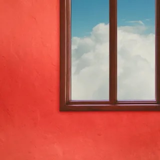 A La Sala album cover. Reddish Pink wall with a large window on the top-right of the frame. Outside the window is a blue sky with clouds.